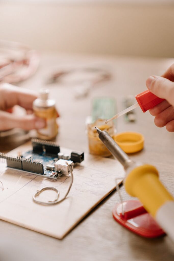 Detailed close-up of hands soldering a printed circuit board with precision.